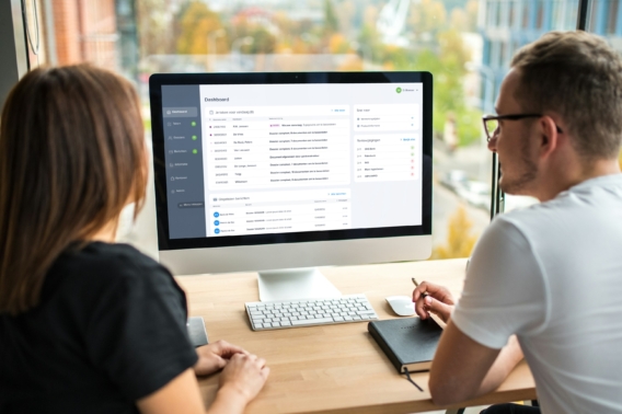 Afbeelding man en vrouw achter een computer